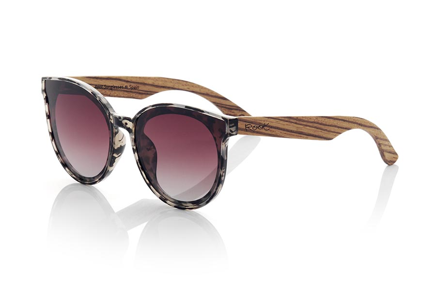 Wood eyewear of Walnut modelo INTHIRA. INTHIRA sunglasses are made with the front in transparent CAREY colored PC material in shades of black, white and brown tones and the temples in Natural WALNUT wood. Female model with rounded shapes that fits well, the INTHIRA glasses Approx front measurement: 142x55mm | Root Sunglasses® 